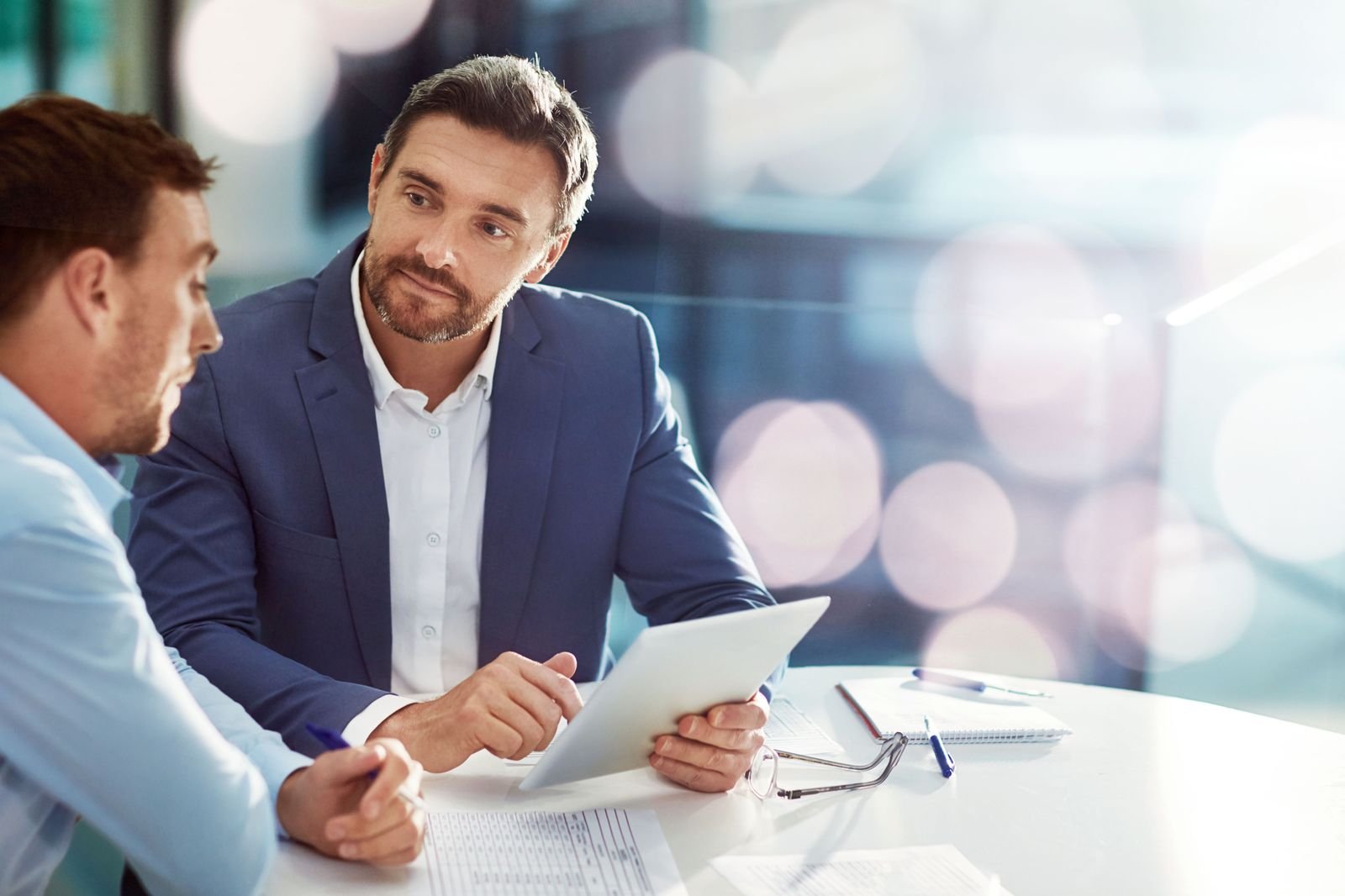 Two professionals in conversation at a meeting table
